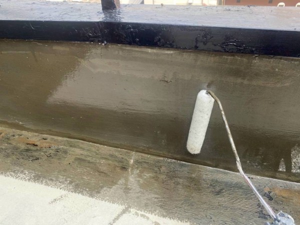 ウレタン防水通気緩衝工法　プライマーを立ち上がりに塗っている